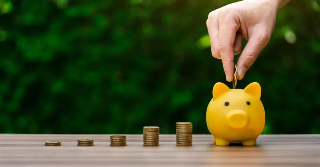 Hand depositing coin into piggy bank FD vs SIP